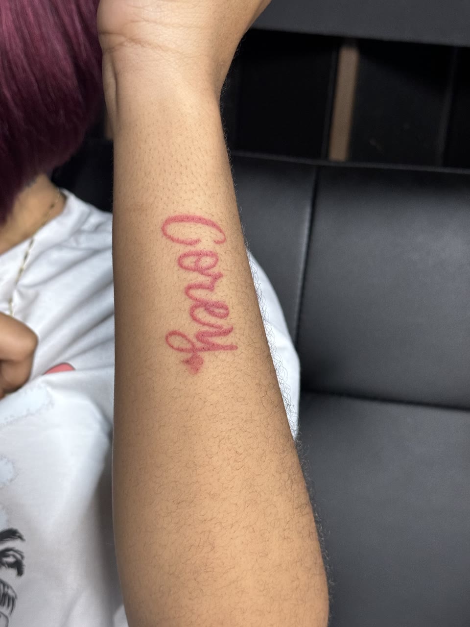Before: red script name tattoo
