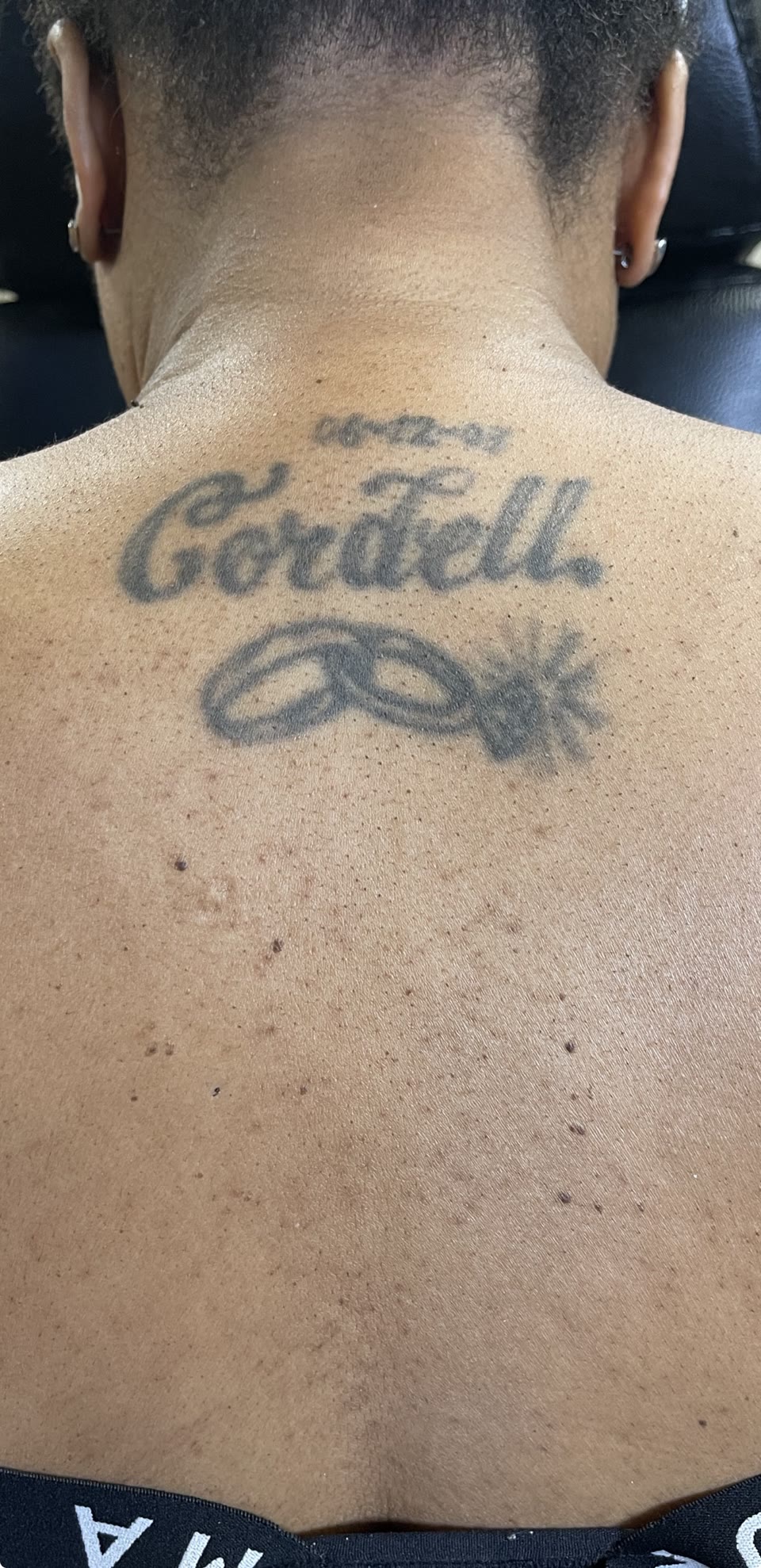Before: faded script tattoo on back