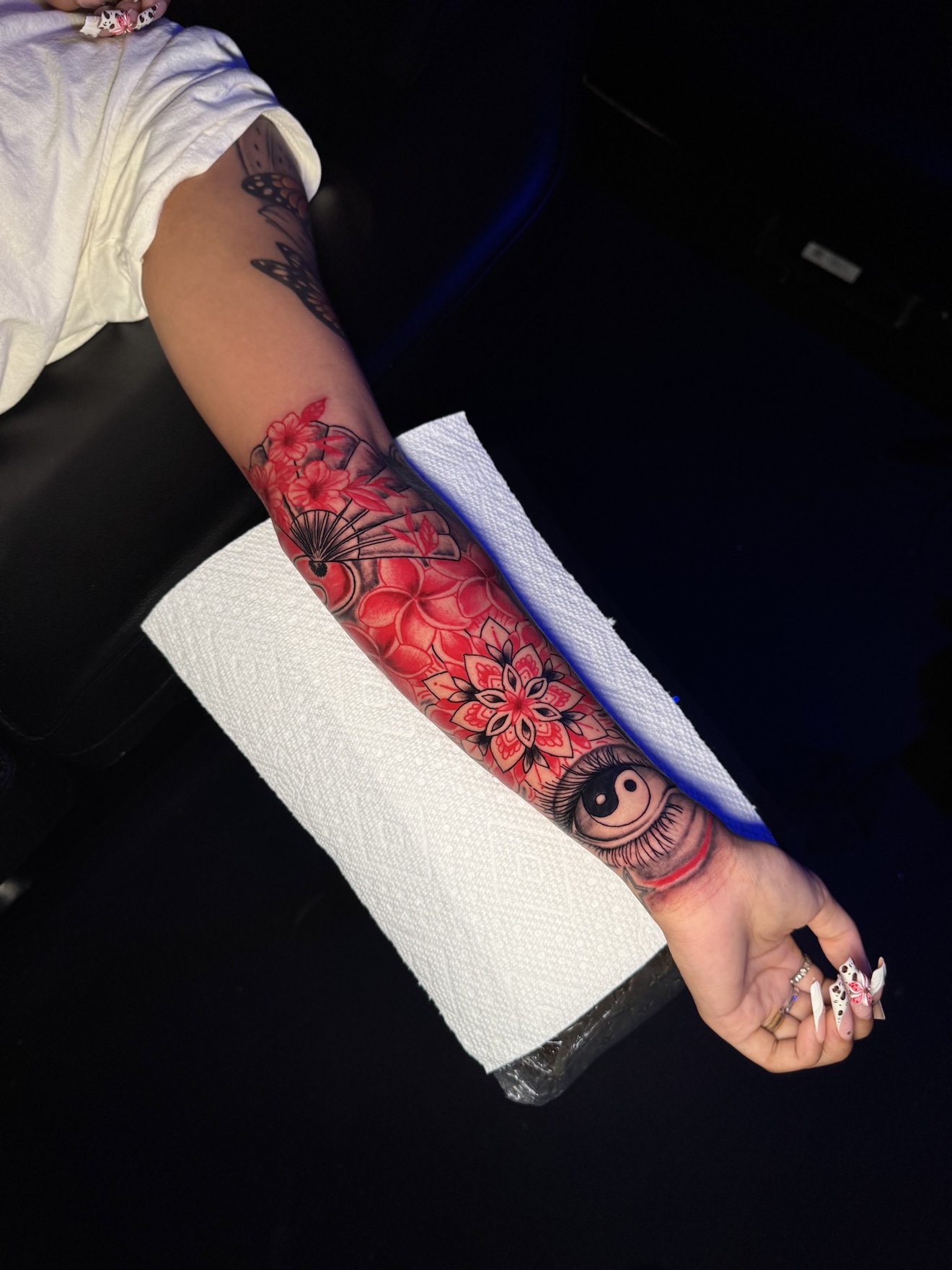 Red floral forearm tattoo